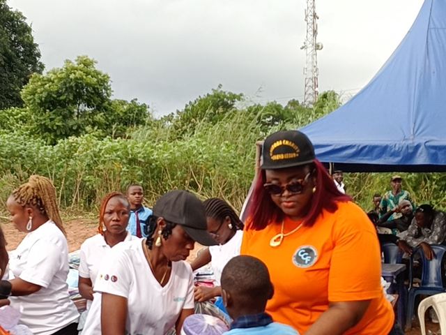 A volunteer checks a pupil's set before handing it over.